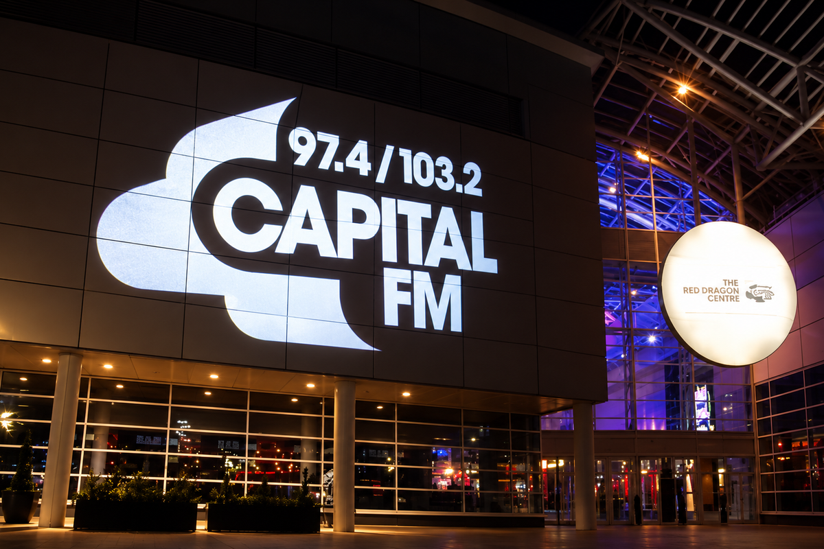 Large Capital FM logo displayed on a building facade at night.