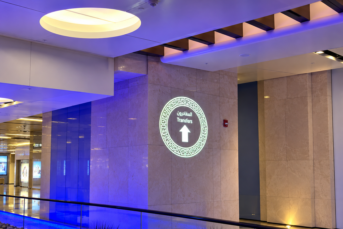 Transfers sign and upward arrow projected onto an indoor wall.