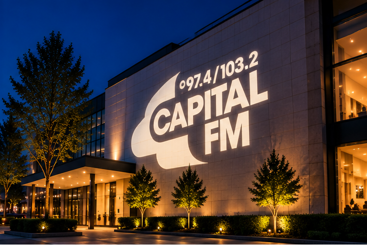 Capital FM radio station building exterior at dusk, with large illuminated white logo text reading '97.4/103.