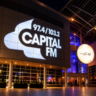 Capital FM logo displayed on a building facade at night